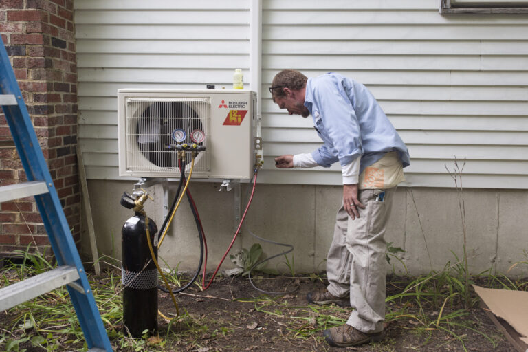Aaron Sinclair, of Dave's World, installs a heat pump at the home of Roland and Dale Bois on Sept. 25, 2018. Credit: Brianna Soukup/Portland Portland Press Herald via Getty Images