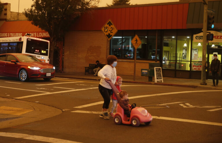 A woman and her children cross the street at the intersection of Fruitvale Avenue and MacArthur Boulevard in the Dimond District of Oakland, California, on Wednesday, Sept. 9, 2020. Credit: Jane Tyska/Digital First Media/East Bay Times via Getty Images