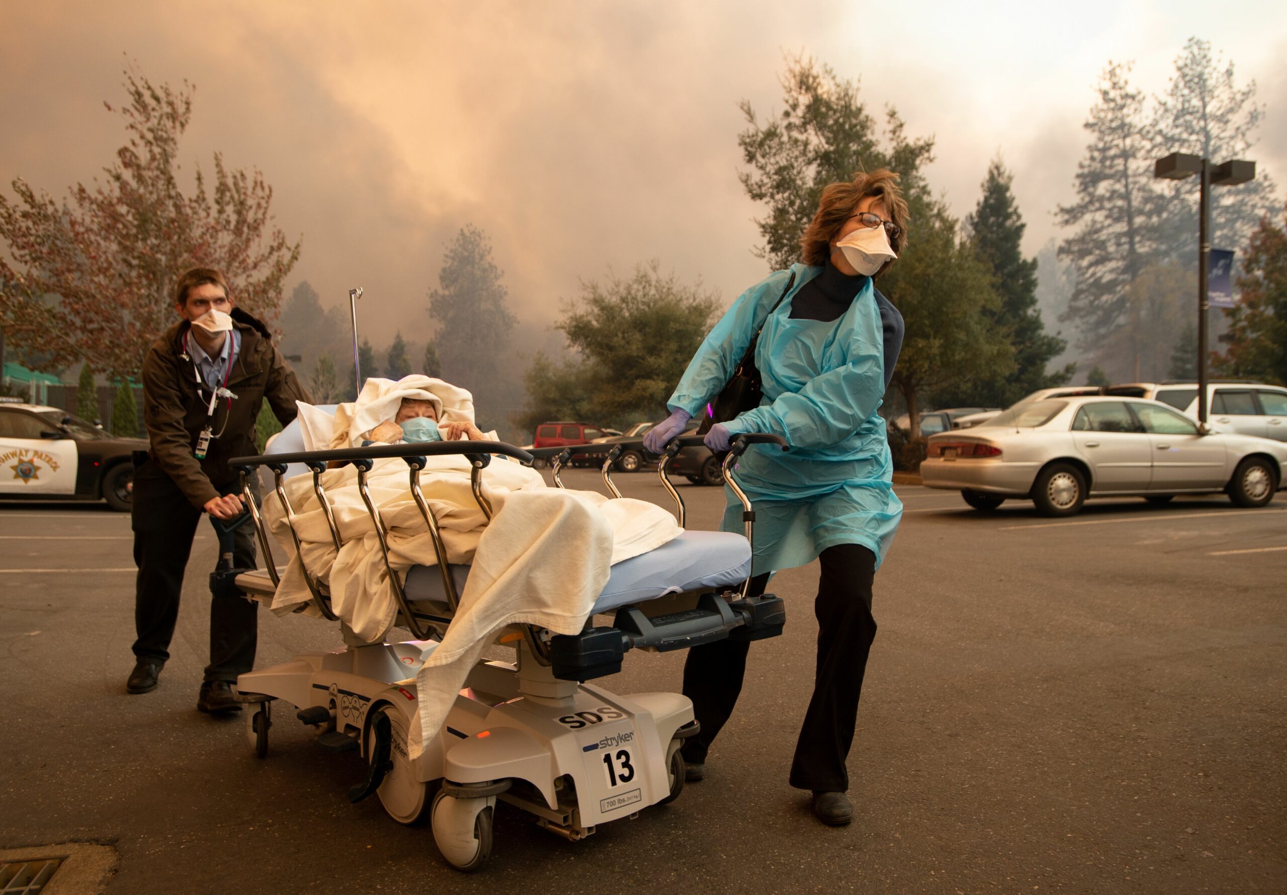 Patients are quickly evacuated from the Feather River Hospital as it burns down during the Camp fire in Paradise, California on November 8, 2018. Credit: Josh Edelson/AFP via Getty Images