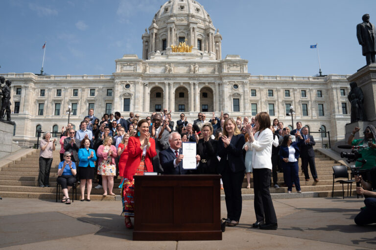Along with DFL legislative leaders and his commissioners, Minnesota Gov. Tim Walz threw a ceremonial budget bill-signing party on May 24, 2023 on the State Capitol steps. Credit: Glen Stubbe/Star Tribune via Getty Images