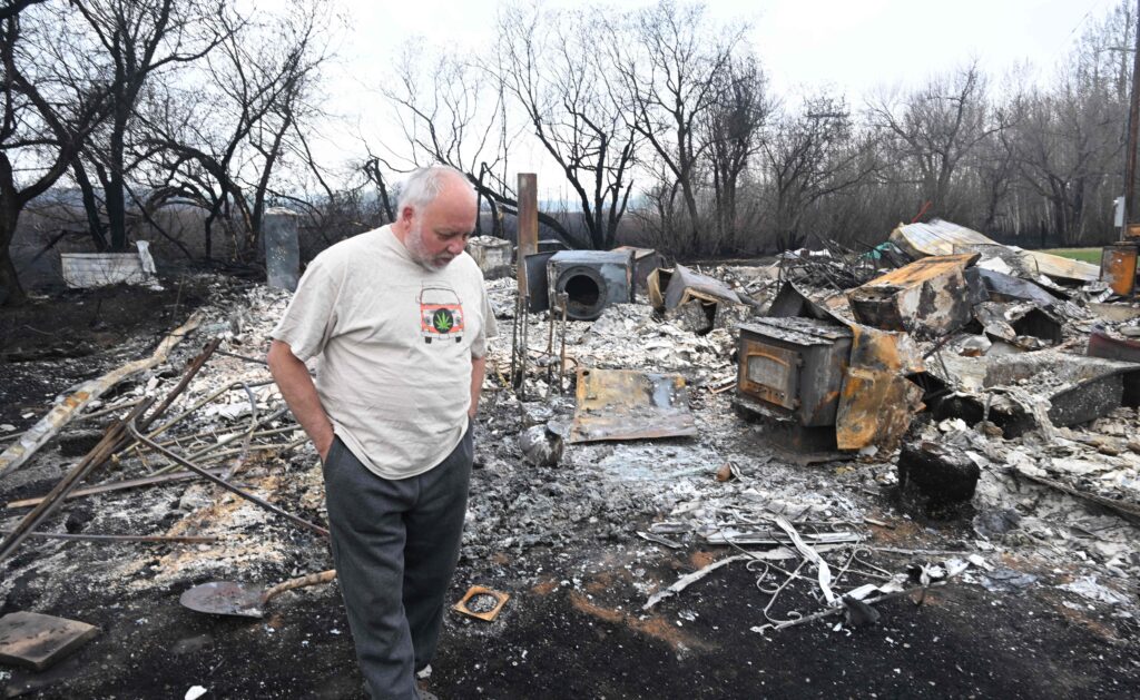 Adam Norris surveys the wildfire damage at his home in Drayton Valley, Alberta, Canada, on May 8, 2023. - Canada struggled on Monday to control wildfires that have forced thousands to flee, halted oil production and threatens to raze towns, with the western province of Alberta calling for federal help. Credit: Walter Tychnowicz / AFP via Getty Images