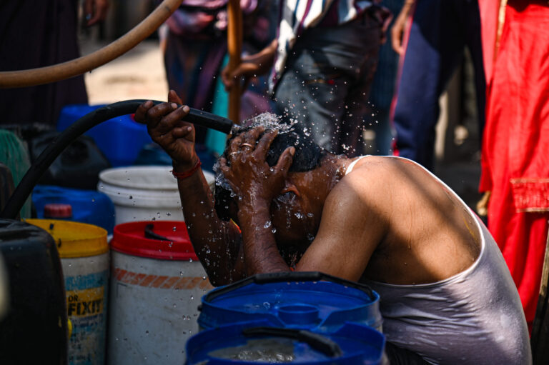 A man dumps water on his head from a Municipal Water Tanker to cool himself outside a slum cluster on a hot summer day in New Delhi, India on May 23, 2023. Credit: Kabir Jhangiani/NurPhoto via Getty Images