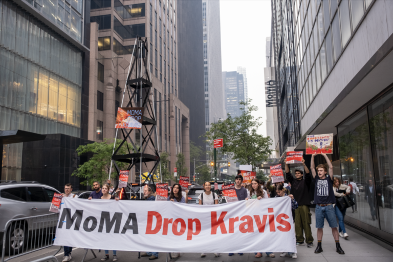 Activists gathered outside MoMA to protest fossil fuel donor Henry Kravis holding signs, a banner, and a model of an oil rig on June 6, 2023. Credit: Keerti Gopal