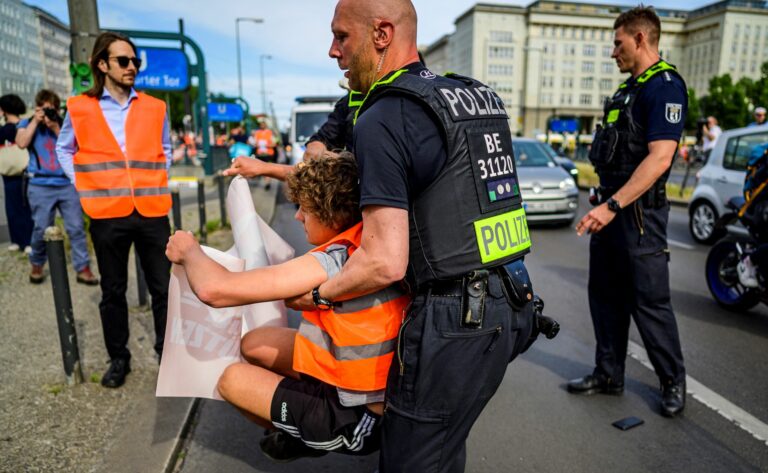 A police officer removes a demonstrator during a march by climate activists of the "Letzte Generation" (Last Generation) group as they walk down Karl-Marx-Allee boulevard on their way to the Chancellery in Berlin on May 31, 2023. Credit: John Macdougall/AFP via Getty Images