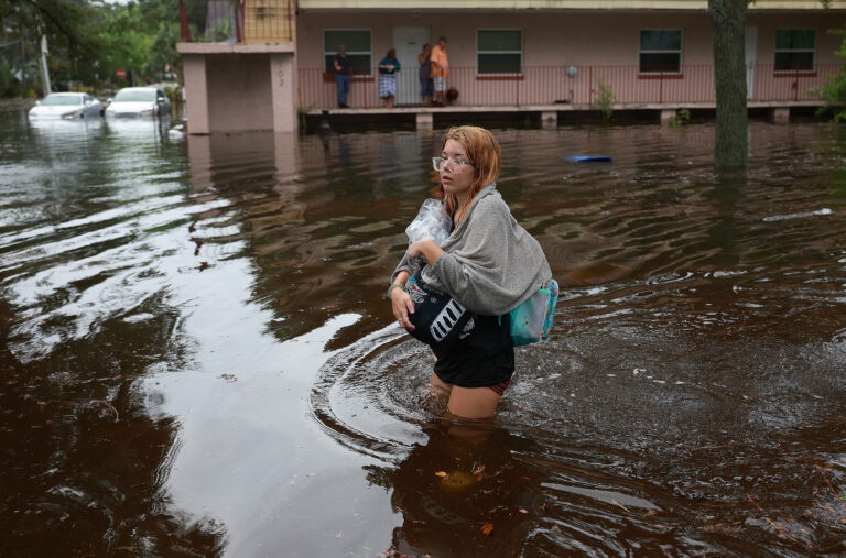 In Tarpon Springs, Florida, Makatla Richter wades through flood waters after having to evacuate her home when the flood waters from Hurricane Idalia inundated it on Wednesday. Credit: Photo by Joe Raedle/Getty Images.