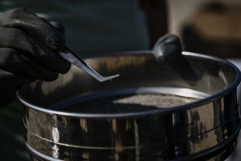 A photo of an individual collecting samples of microplastic