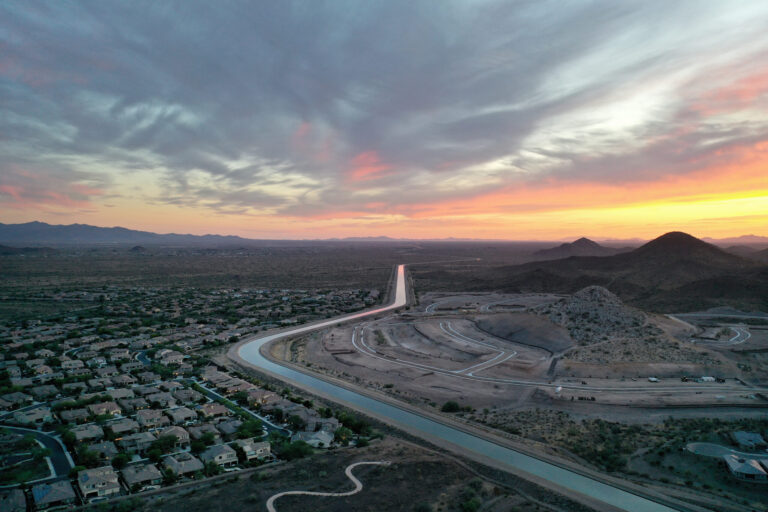 The Central Arizona Project canal runs past homes and new home construction, center right, in the Phoenix suburbs on June 8, 2023 in Peoria, Arizona. The project carries diverted Colorado River water through a 336-mile long system to help serve 80 percent of the population of Arizona. Credit: Mario Tama/Getty Images