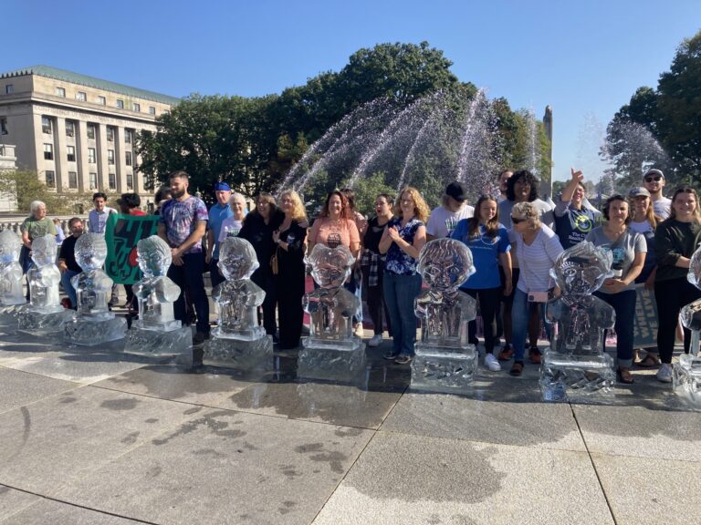 Gathered for a Climate Convergence at the Pennsylvania Capitol in Harrisburg, climate activists on Monday stood behind melting ice sculptures to demand more climate action by Gov. Shapiro and state lawmakers. Credit: Jon Hurdle.