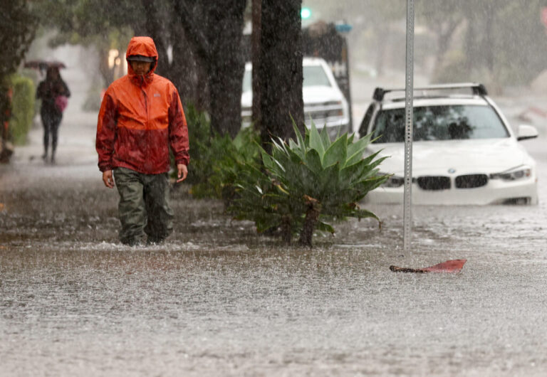A person walks along a flooded street as a powerful long-duration atmospheric river storm impacts California on Feb. 4 in Santa Barbara. Credit: Mario Tama/Getty Images