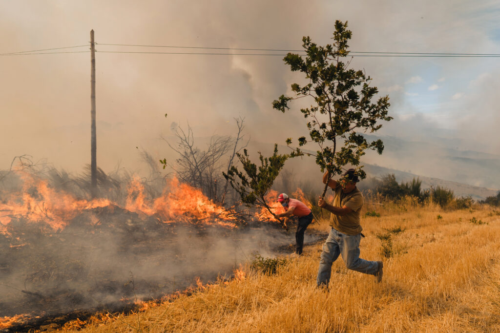 Local residents work to prevent a wildfire from reaching nearby houses on Aug. 19 in Vilela Seca, Portugal. Credit: Pedro Pascual Garcia/Anadolu via Getty Images