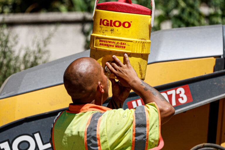 A Los Angeles County crew member hydrates between repaving a road as temperatures reach 100 degrees and above in August 2023. Credit: Robert Gauthier/Los Angeles Times via Getty Images