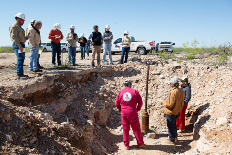 Contractors and attorneys for Chevron watch from above on April 10, 2024 as Hawk Dunlap, Daniel Charest and Sarah Stogner (from left) inspect an excavated well on April 10 at Antina Ranch in Crane County, Texas. Credit: Mitch Borden/Marfa Public Radio