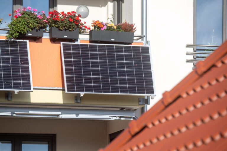 Plug-in solar panels hang from a balcony in Stralsund, Germany. Credit: Stefan Sauer/picture alliance via Getty Images