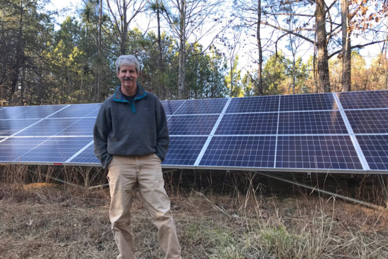 Mark Johnston, a plaintiff in the case, stands with the 6 kW solar array at his Alabama home. Credit: Courtesy of Southern Environmental Law Center