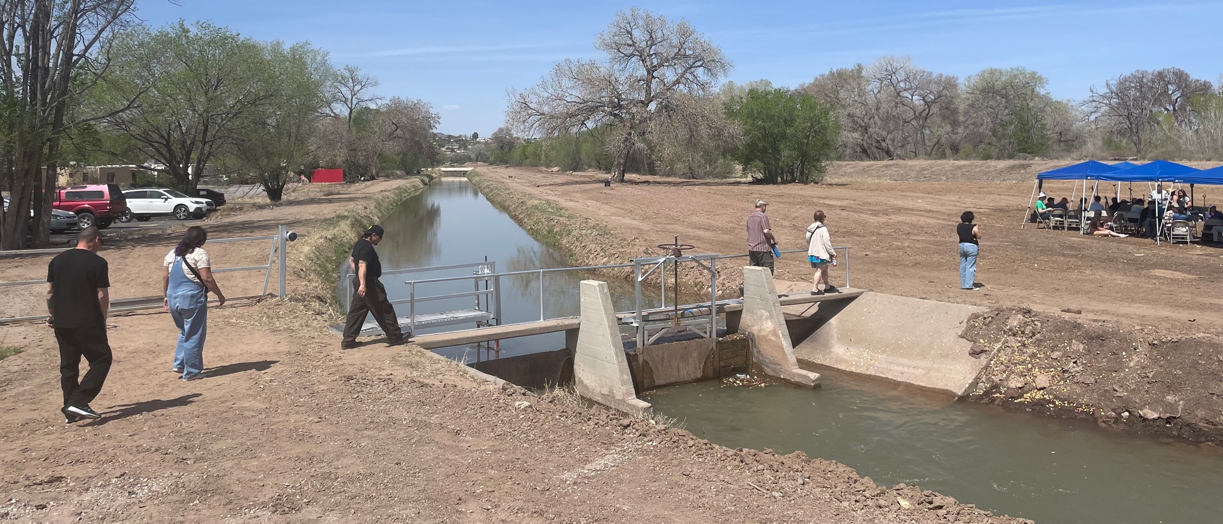 Les gens traversent un pont sur l'Atrisco Acequia Madre lors de l'événement Primera Agua à Albuquerque. Crédit : Tina Deines/Pacte Climat