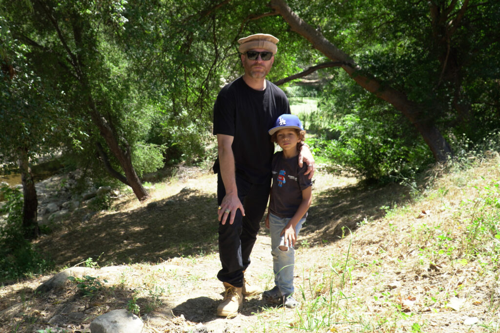 Ethan Higbee se tient avec son fils Noah, âgé de 6 ans, dans la zone où la marée noire a eu lieu six mois plus tôt. Crédit : Steven Rodas/Pacte Climat