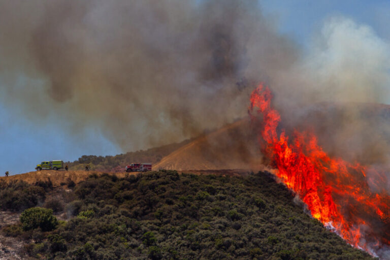 Firefighters work to combat a hotspot in the hills while the Sandy Fire continues to burn near a residential area on Wednesday in Simi Valley, Calif. Credit: Apu Gomes/AFP via Getty Images