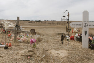Des tombes marquent le site du massacre de Wounded Knee en 1890 dans la réserve de Pine Ridge dans le Dakota du Sud, où les troupes américaines ont tué plus de 250 hommes, femmes et enfants Lakota. Crédit : Carla Samon Ros/CJI