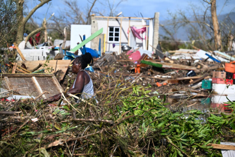 A woman clears debris near a damaged building on Oct. 29, 2025, following the passage of Hurricane Melissa in Black River, Jamaica. Credit: Ricardo Makyn/AFP via Getty Images