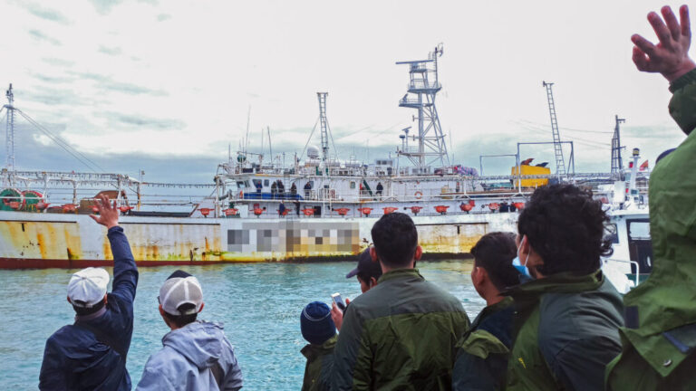 Fishers wave from onboard a Chinese-flagged squid jigger. Credit: Environmental Justice Foundation