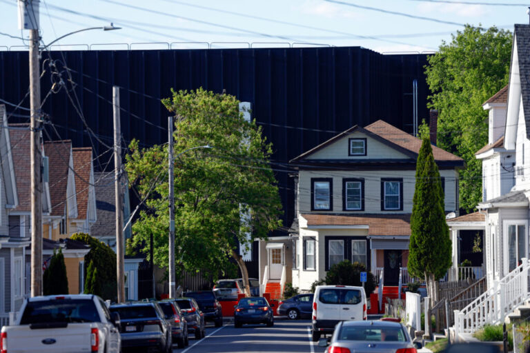 Lowell, MA - May 12: The view down a street in Lowell, Mass., where a data center looms behind residential housing on May 12. Credit: Danielle Parhizkaran/The Boston Globe via Getty Images