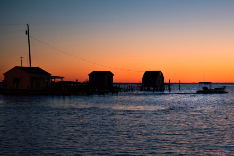 A fisherman passes crab shanties during sunrise Tangier, Va. Credit: Jim Watson/AFP via Getty Images